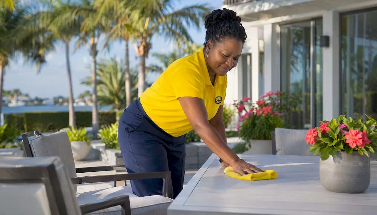 Housekeeper cleaning foyer in bright coastal home
