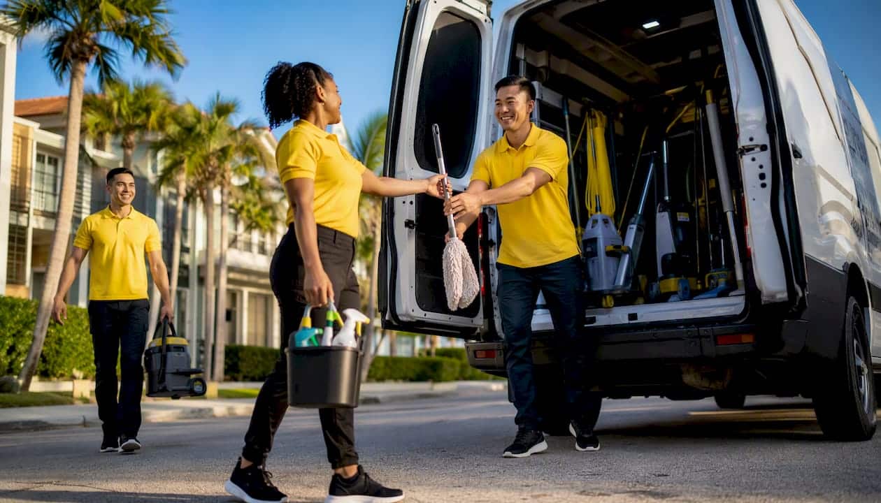 Cleaning crew loading supplies into van outdoors