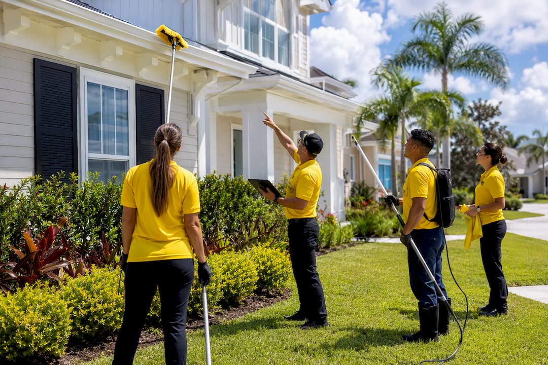 Cleaning crew inspecting Florida home exterior