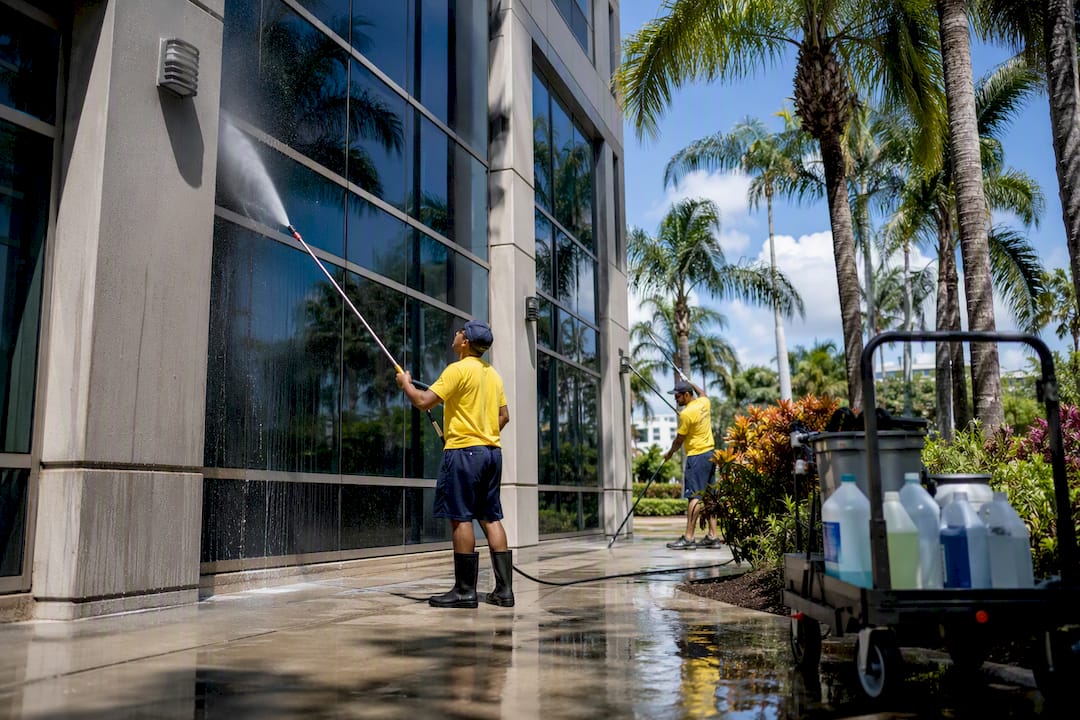 Commercial cleaning crew pressure washing office exterior